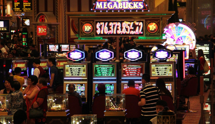 A crowded casino floor with people playing slot machines under the Megabucks jackpot sign